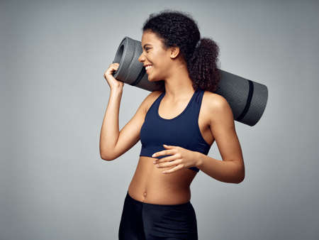 Dark-skinned African American woman posing in a tracksuit and doing sports