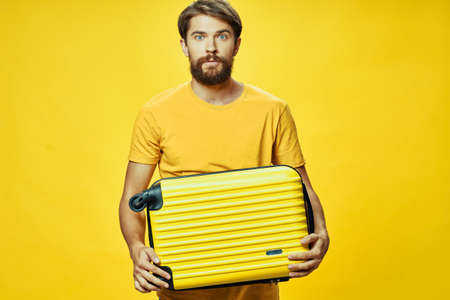 Male traveler with a suitcase in his hands posing in studioの写真素材