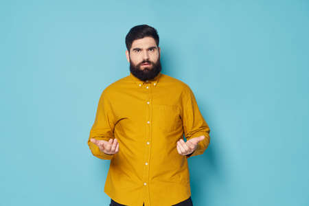 Bearded man in shirt emotion discontent gesturing with handsの写真素材