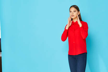 beautiful girl in red shirt touching face with hands modelの写真素材
