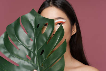 A woman of Asian appearance with a green leaf and makeup modelの写真素材