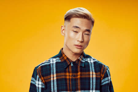 Cute guy in a plaid shirt with his eyes closed