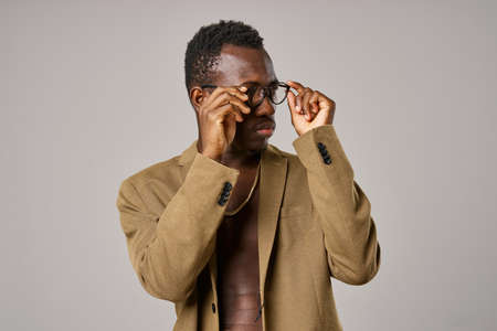 A guy of African appearance with glasses and jacket