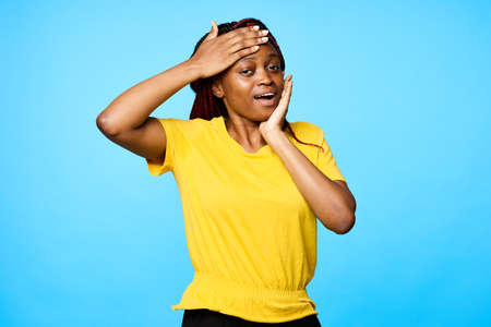 A woman of African appearance touches her face with her handsの写真素材
