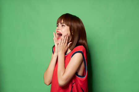 Emotional woman with wide open mouth on a green background free place