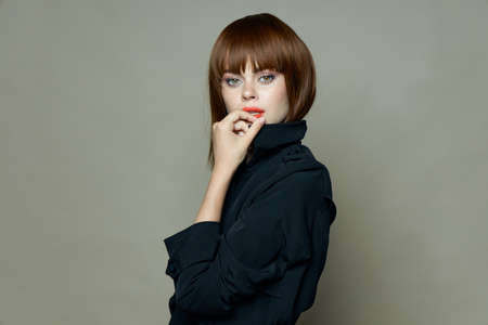 Charming woman in a black coat looks at the camera