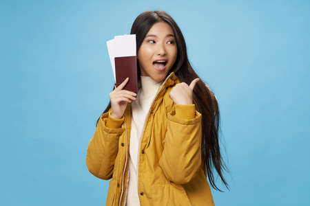 woman with tickets and passport shows a positive gesture