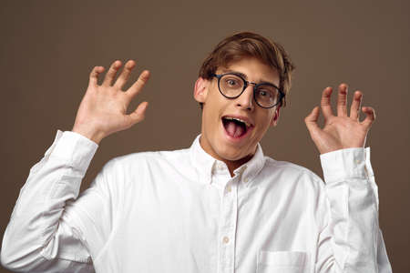 Emotional Guy with glasses shows surprise with his hands
