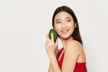 Woman with avocado on isolated background dietの写真素材