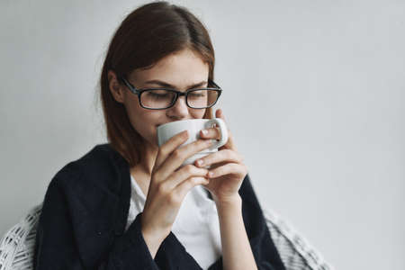 Woman drinking coffee at home armchair interior enjoyingの写真素材