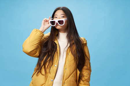 White glasses in the hands of a beautiful woman of Asian appearance