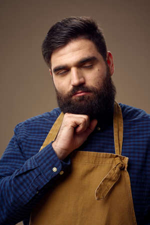 hairdresser in beige apron and blue shirt on isolated backgroundの写真素材