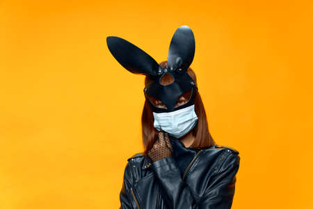Female rabbit mask posing sexually in a medical mask from coronavirus