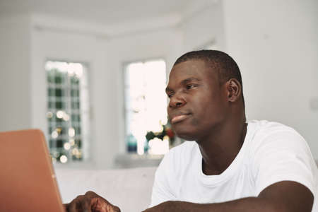 Working in front of laptop at home African man of appearance