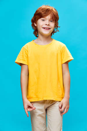 happy redhead child in yellow t-shirt connected forefinger and thumbの写真素材