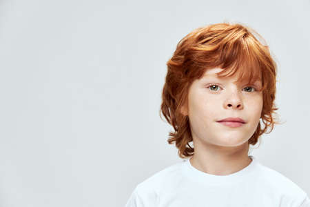 Cute redhead boy cropped view white t-shirt freckles on face close-upの写真素材