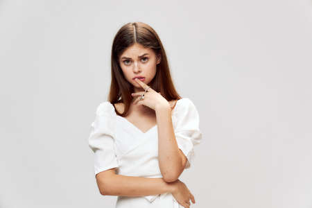 Girl holding a finger on her lips white dress cropped view
