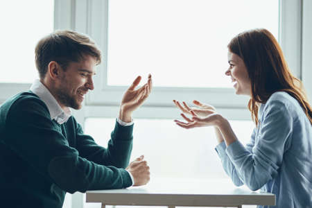 A man and a woman are sitting at the table communicatingの写真素材