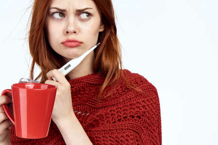 Sick woman covering herself with a plaid cure flu medicine for warming drink health problems