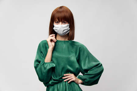 Woman in fashion dress posing in medical mask virus covid-19の写真素材