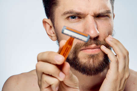 Man with razor in hand beard facial skin care morning lifestyle clean skinの写真素材