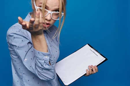 woman with a folder in hand on a blue background in a shirt official work