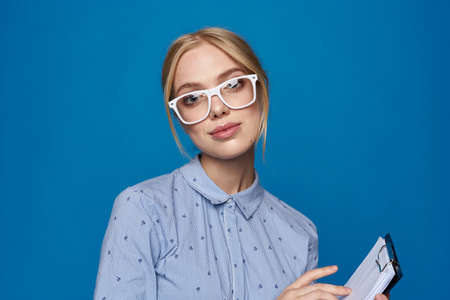 business woman blonde in glasses with documents work blue shirt