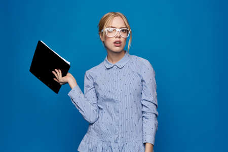 woman with a folder in hand on a blue background in a shirt official work