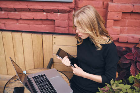 Woman blonde laptop and tablet in cafe freelancer workの写真素材