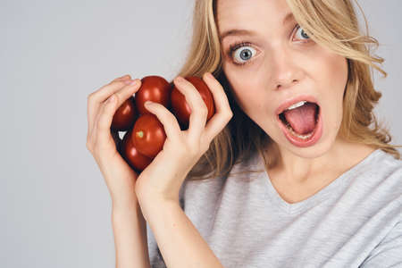 emotional woman with groceries in hands on gray background food model cropped view