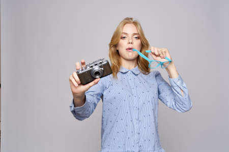 Beautiful blonde woman holding a camera smiling close-up cropped view