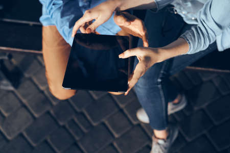 sitting on a bench with a tablet in hand communication internet technologyの写真素材