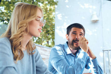 Man and woman communicate in the park outdoors in blue shirts employees friends work