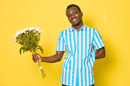 Cheerful man with bouquet of flowers gift dating romance african appearanceの写真素材