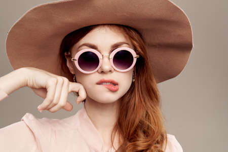 red-haired woman in hat and shirt on beige backgroundの写真素材