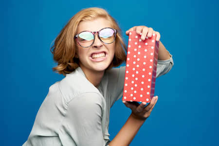 Blonde woman with red gift box in hands