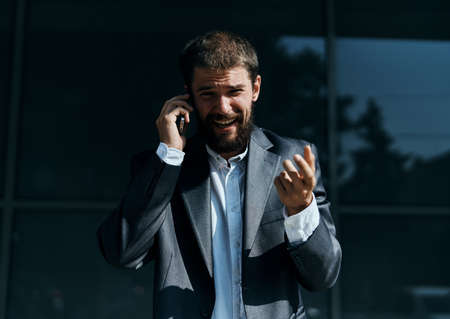 Business man communicates on the phone outdoors emotions executive manager lifestyleの写真素材