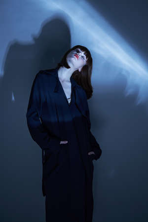 Stylish person coat dark room casual wear and beautiful faceの写真素材