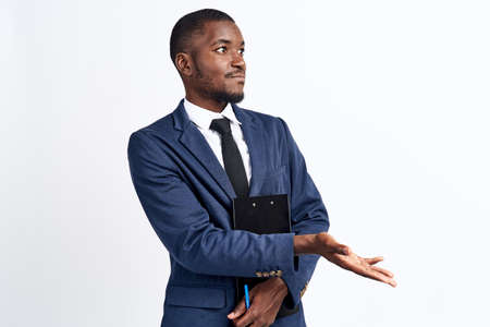 portrait of a handsome man of African appearance in a suit on a light background cropped view...