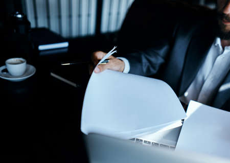 business man in suit in front of laptop with book work communication technology