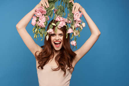 Beautiful woman with a bouquet of pink flowers on a blue background spring model