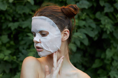 Beautiful woman face mask Holds hand near neck front view dermatologyの写真素材
