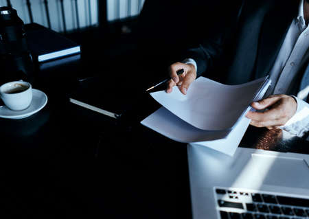 business man in a cafe at the table in front of a laptop work a cup of coffee at the table communication technologyの写真素材
