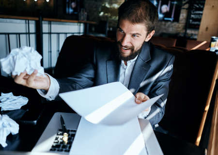 Business man in a cafe sitting at the table documents laptop crumpled paper executive lifestyle...