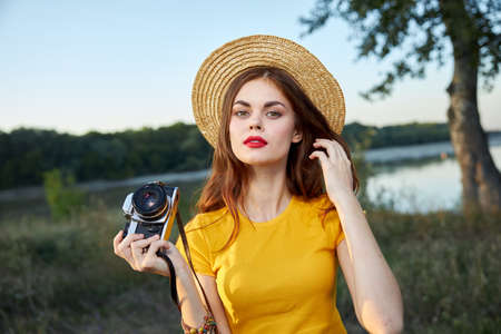 Woman in a hat with a camera in her hands red lips attractive look natureの写真素材