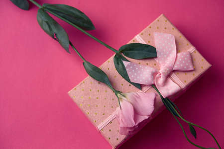 gift box and bouquet of flowers on pink background bow holidays top viewの写真素材