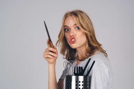 woman with kitchen appliances on gray background emotions model housewifeの写真素材