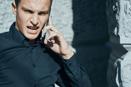 Business man in a shirt near the building with documents in his handsの写真素材