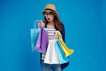 pretty woman with packages in hands n shopping consumption lifestyle blue background