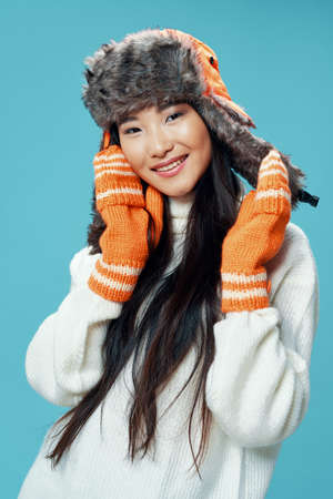 Woman in winter hat with gloves white sweater coolの写真素材